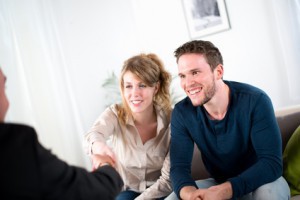 cheerful young couple with a consultant salesman